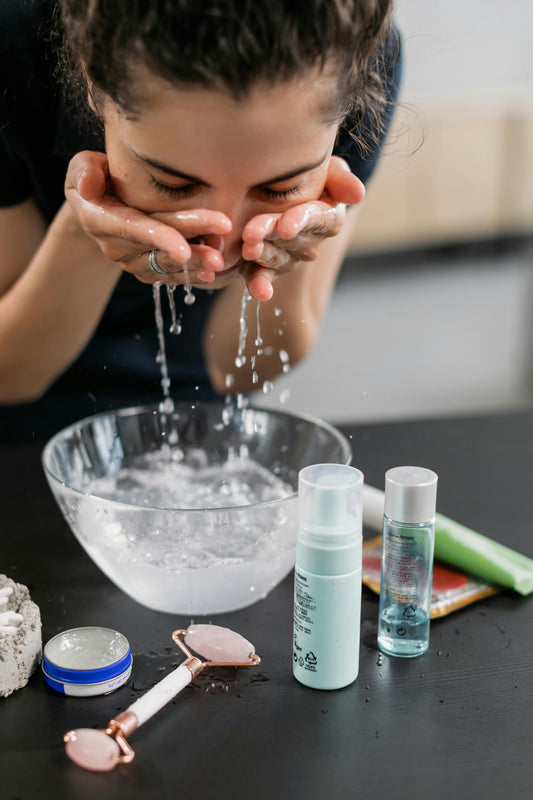 young women washing her face in using a bowl