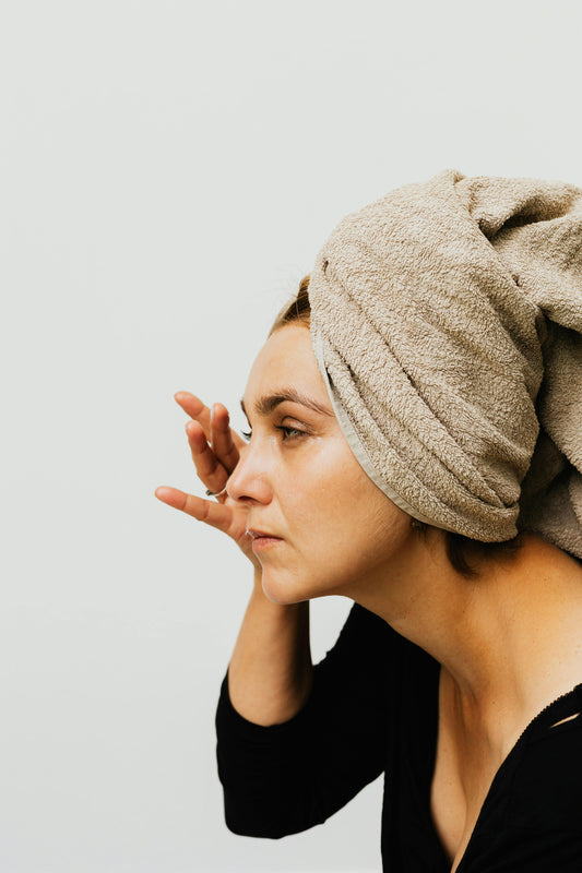 skincare routine of a women with head wrapped in a towel towel