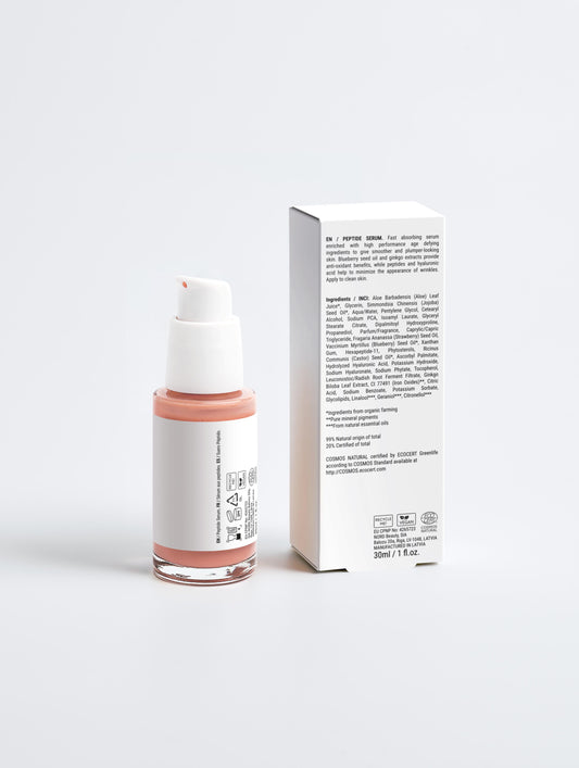 Skincare bottle with pink base and white cap next to its packaging on a light gray background