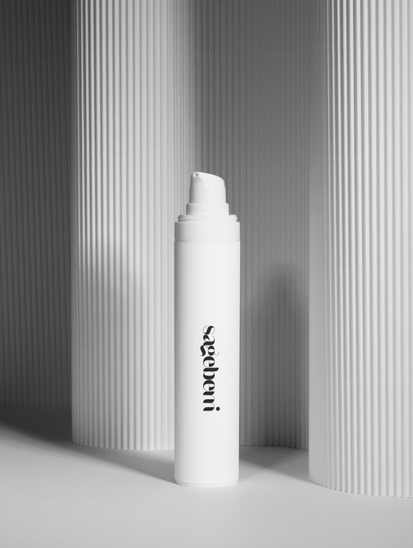 A white cylindrical cosmetic bottle with a pump dispenser, standing upright in front of gray ribbed columns. The bottle features the brand name 'sophi' printed vertically in black near the lower half.