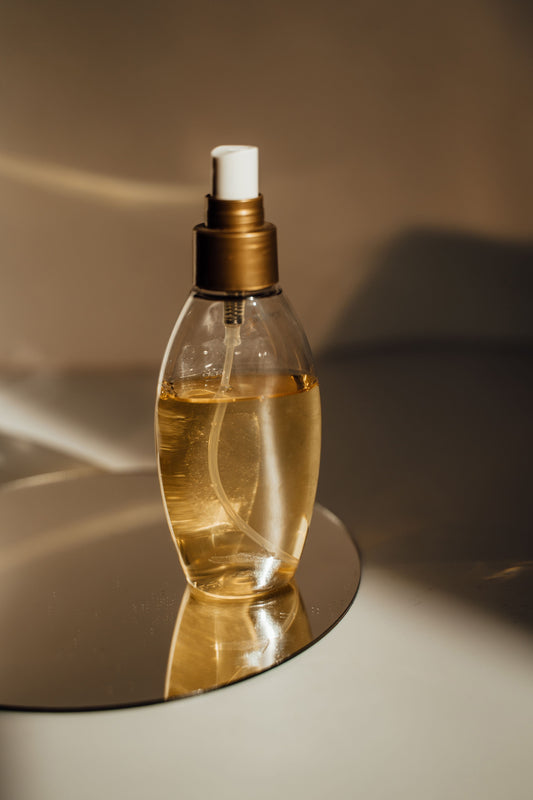Small transparent bottle containing light brown deodorant liquid