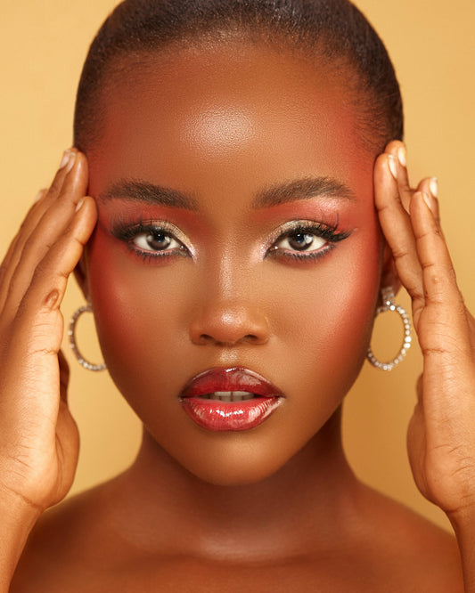 The face of a beautiful, brown-skinned young woman wearing expertly applied makeup 