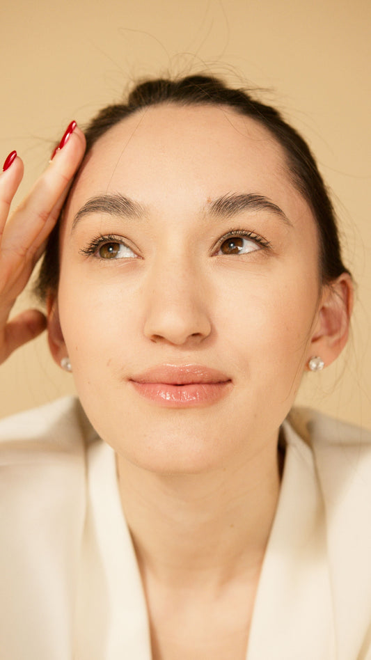 Portrait of a smiling, dark-haired young woman with a glowing complexion