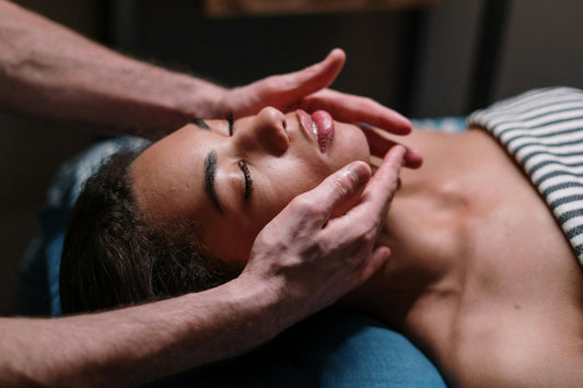 A woman's neck and face are being massaged