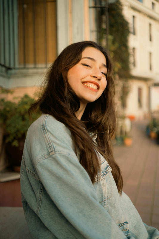 Portrait of a young dark-haired woman wearing a light blue denim jacket