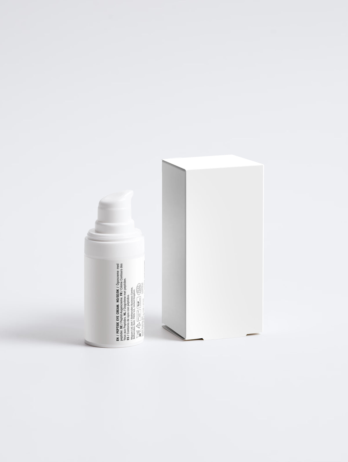 A minimalist white peptide eye cream in an airless pump bottle beside a blank white box, labelled in multiple languages with vegan, recyclable and COSMOS certification marks.